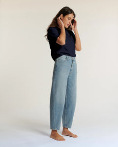 Jean pour femme en denim bleu clair, coupe droite et légèrement large, matière 100 % coton offrant un confort naturel et un style décontracté.