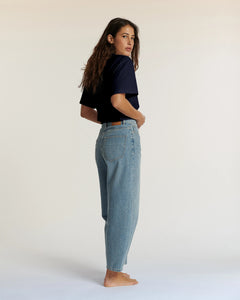 Jean droit en denim bleu clair 100% coton avec une coupe légèrement ample adaptée à toutes les morphologies féminines, offrant confort et style décontracté.