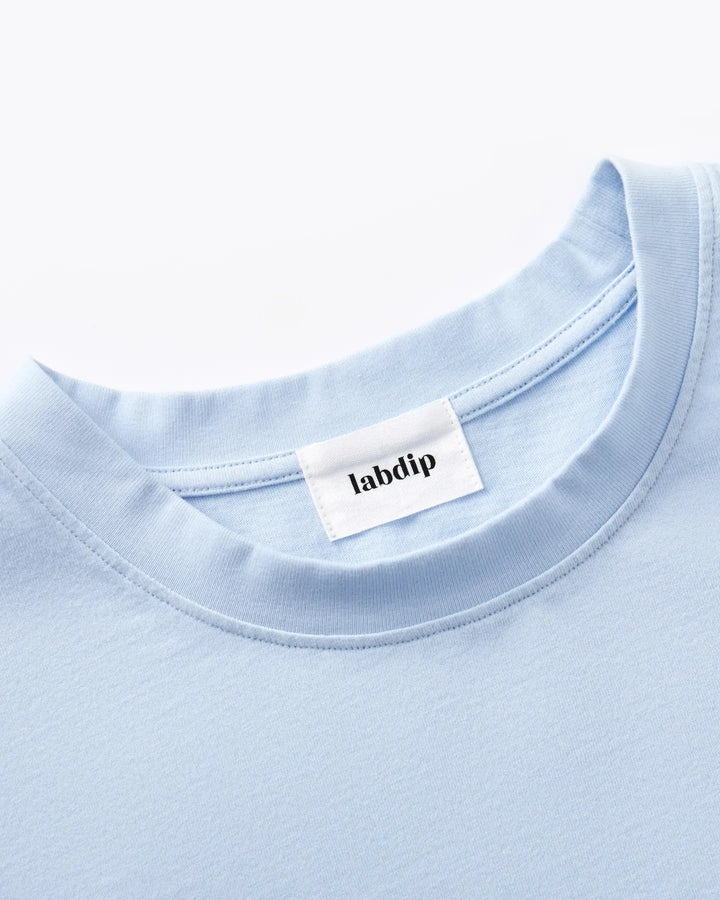 T-shirt en coton bleu clair avec col rond et étiquette Labdip, textile doux et confortable, idéal pour un look casual et estival.
