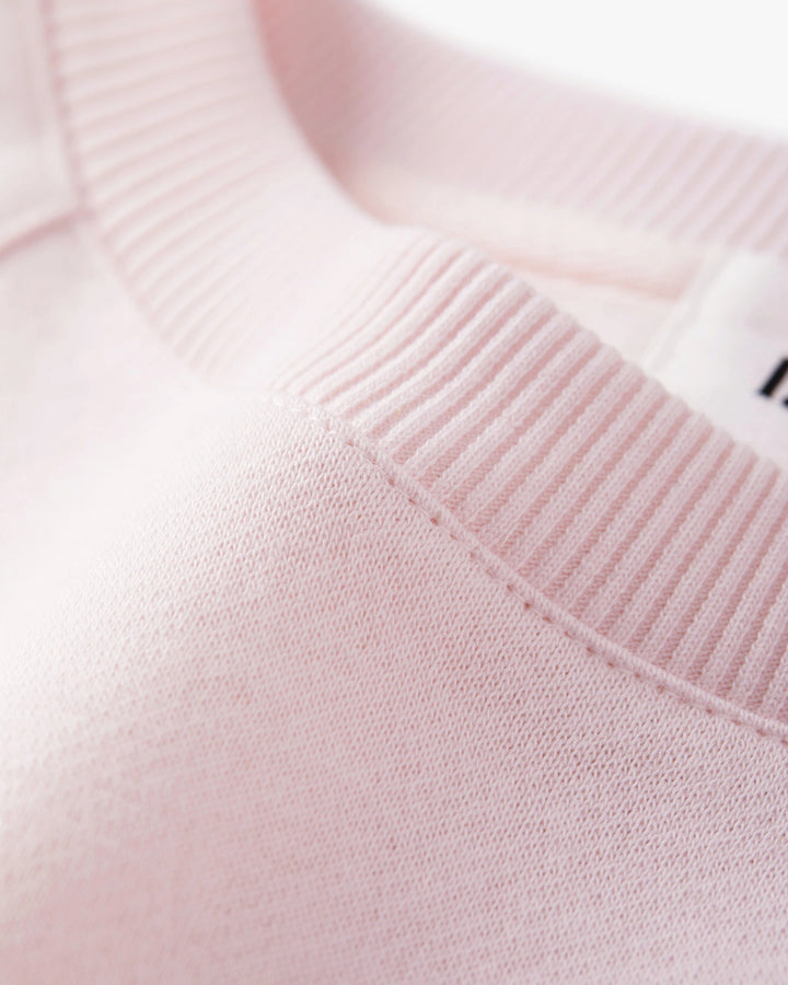 pull en coton rose pastel avec col rond côtelé, maille douce et confortable adaptée à un style décontracté féminin