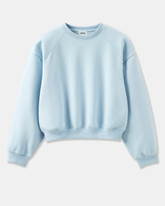 Sweat-shirt femme en coton doux de couleur bleu clair, coupe classique avec manches raglan et bord-côtes aux poignets et à la taille pour un confort décontracté.