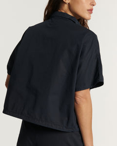 Pantalon en popeline coton bleu marine, coupe droite et ajustée, offrant un tombé fluide et élégant adapté à toutes les morphologies féminines.