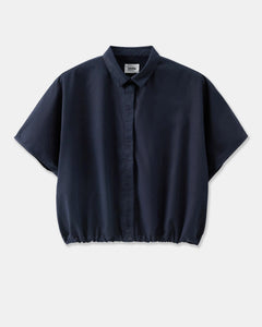 Chemise fluide en popeline bleu marine, coupe ample avec col classique et bas élastiqué, idéale pour un style décontracté et élégant.