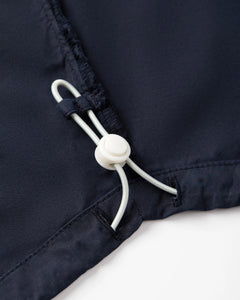 Détail d’un jean en popeline navy, tissu léger 100% coton, avec un cordon de serrage ajustable pour un maintien personnalisé et un confort optimal.