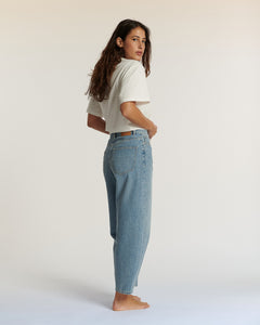 Jean en denim bleu clair 100% coton avec une coupe droite et légèrement ample, offrant un confort idéal pour toutes les morphologies féminines.