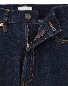 Jean droit en denim brut foncé avec coutures contrastées, bouton métallique gravé, fermeture éclair et matière 100 % coton adaptée aux morphologies féminines.