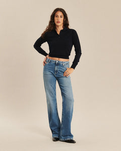 Jean bootcut en denim bleu délavé avec une coupe évasée à partir du genou, matière 100 % coton offrant un style rétro et confortable, adapté à toutes morphologies.