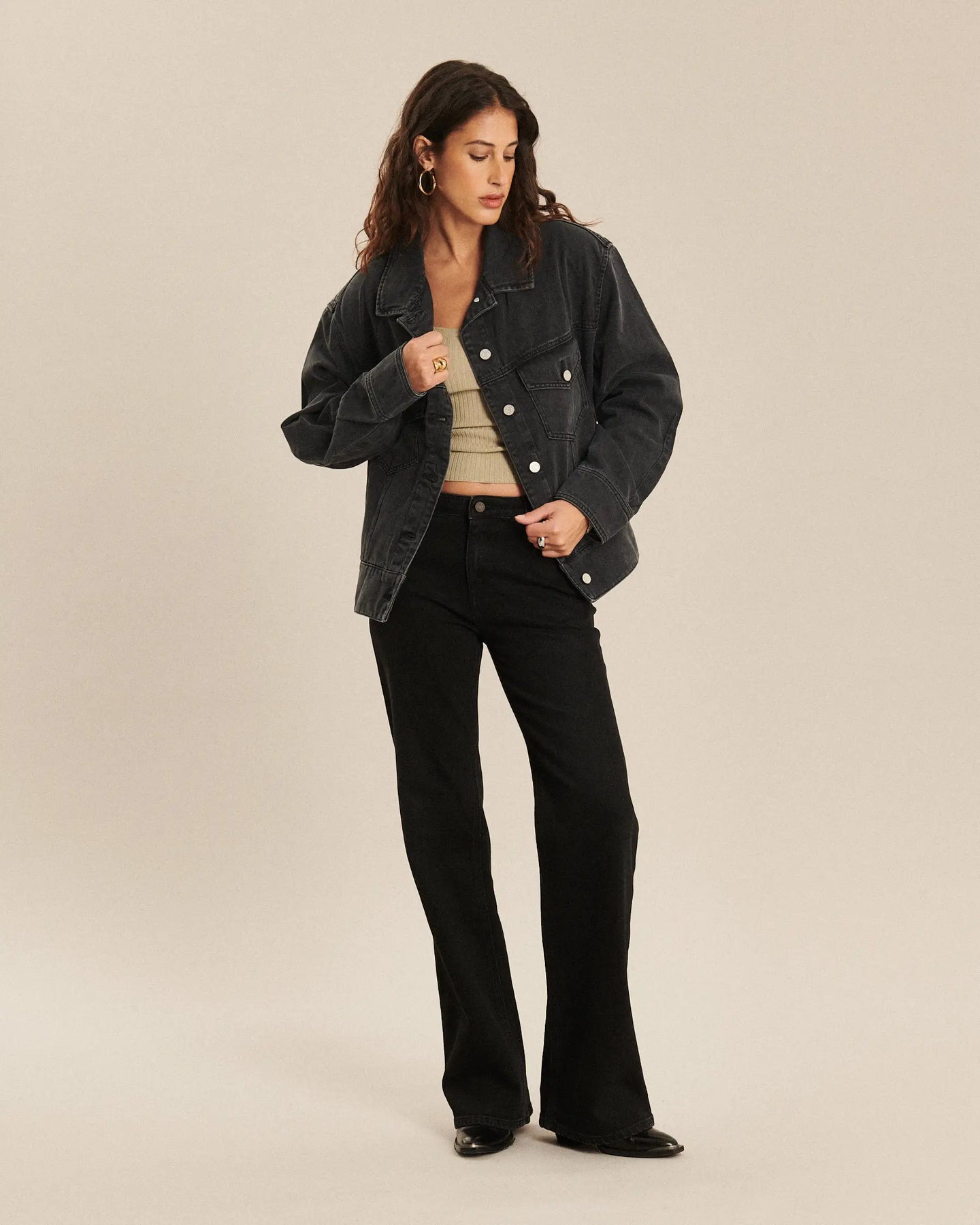 Jean pour femme en denim noir charbon, coupe bootcut ajustée et légèrement évasée, avec une matière confortable et épurée qui s’adapte à toutes les morphologies.