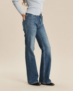 Jean pour femme en denim bleu moyen, coupe bootcut avec un léger évasement au bas, fabriqué en coton, offrant une silhouette confortable et adaptée à toutes les morphologies.