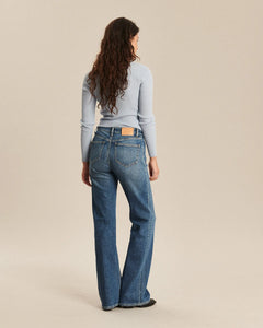 Jean en denim bleu moyen avec coupe bootcut, matière 100 % coton, s’adaptant à toutes les morphologies pour un look féminin et confortable.