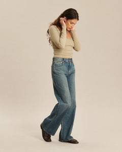 Jean denim en coton bleu indigo avec coupe droite large, matière robuste et aspect légèrement délavé, conçu pour s’adapter aux morphologies féminines.