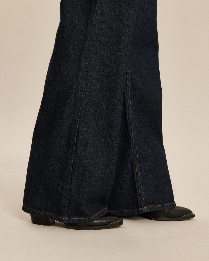 Jean large en denim bleu foncé 100% coton avec une coupe flare et une fente sur le côté, idéal pour femme recherchant confort et élégance.
