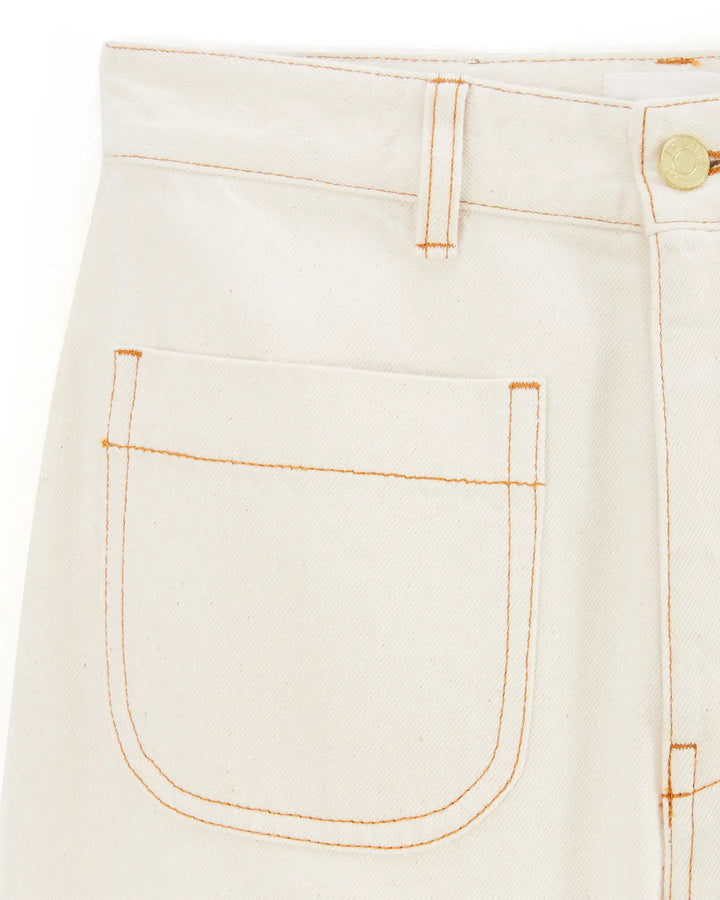 Jean femme en denim écru clair en coton, coupe droite avec surpiqûres contrastées orange, tissu rigide idéal pour un style casual et estival.
