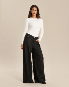 Jean femme en denim gris foncé, coupe large et fluide, tissu en coton épais, ajusté à la taille et ample sur les jambes pour un confort optimal.