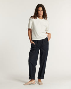 Pantalon en popeline bleu marine pour femme, coupe droite et ample, matière légère en coton idéale pour l'été, avec poches latérales et chevilles retroussées.