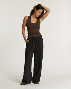 Pantalon fluide marron foncé en tissu Tencel, coupe large et taille élastiquée, adapté à toutes morphologies pour un confort optimal.