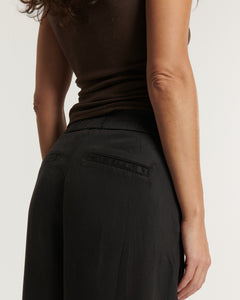 Pantalon femme en tissu Tencel marron foncé, coupe droite et fluide avec poches arrière passepoilées, s'adaptant parfaitement à toutes les morphologies.
