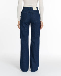 Jean droit en denim brut bleu foncé, coupe féminine et intemporelle, confectionné en coton 100 % pour un confort optimal et adapté à toutes les morphologies.