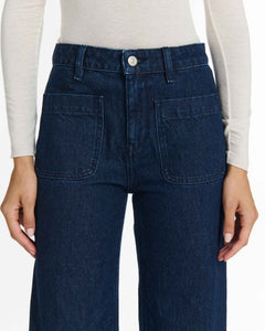 Jean femme en denim brut bleu foncé, coupe droite avec poches plaquées sur le devant, confection 100% coton pour un confort et une tenue naturelle.