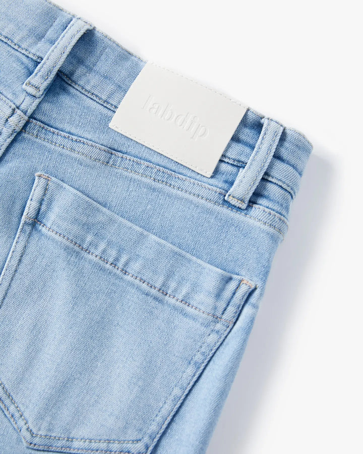 Jean droit en denim bleu clair 100 % coton avec une finition douce, poche arrière classique, coupe ajustée pour femme, idéal pour un style casual et estival.