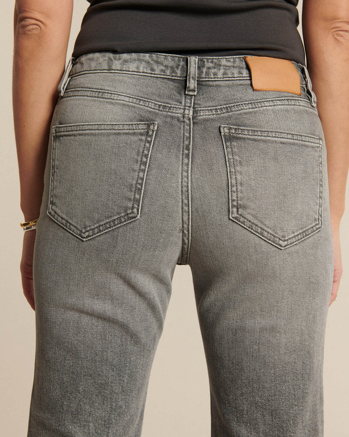 Jean denim gris clair en coton, coupe droite ajustée, conçu pour épouser toutes les morphologies féminines avec confort et style.