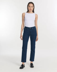 Jean droit en denim brut bleu foncé, coupe ajustée et taille haute, en coton renforcé pour un confort optimal et une silhouette féminine élégante.