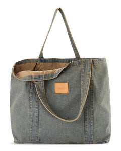 Sac en denim bleu délavé de style casual avec une texture en coton robuste, idéal pour un usage quotidien et un look décontracté.