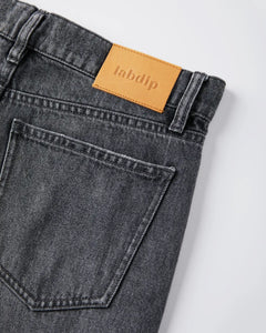 Jean femme en denim 100 % coton de couleur gris poussiéreux, coupe droite avec poche arrière classique et étiquette en cuir beige marqué Labdip.