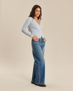 Jean en denim bleu moyen, coupe droite et ample, matière 100 % coton, conçu pour s'adapter à toutes les morphologies féminines avec un style décontracté.
Porté par le mannequin de face