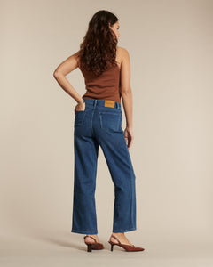 Jean droit en denim bleu profond, coupe ample et fluide, conçu en coton de qualité pour un confort optimal et une silhouette féminine élégante.