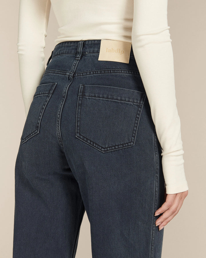 Jean 100 % coton de couleur bleu foncé avec coupe droite et taille haute, offrant un ajustement confortable et élégant pour toutes les morphologies.