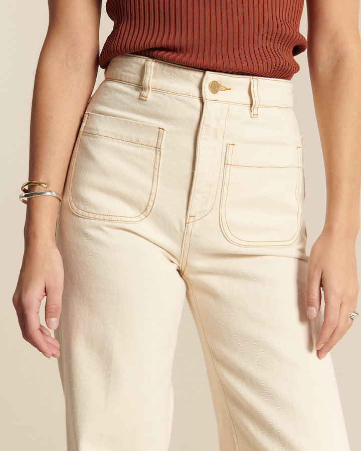 Jean en denim écru clair 100% coton avec coupe droite et taille haute, adapté à toutes les morphologies pour un look estival décontracté et élégant.