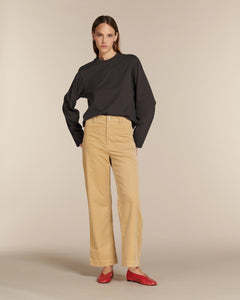 Jean beige en coton avec coupe droite et taille haute, matière douce et confortable, fit adapté à toutes les morphologies, porté avec des ballerines rouges.