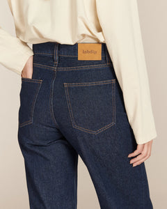 Jean droit long en denim brut 100% coton, coupe ajustée et taille haute, avec coutures contrastantes et patch en cuir marqué Labdip pour un look féminin et moderne.
porté par le mannequin détail