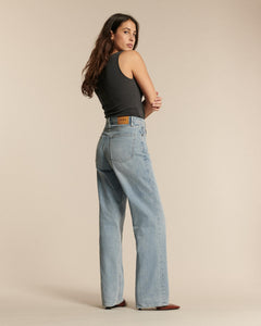 Jean femme en denim clair stone bleach, coupe droite longue avec taille haute, offrant un fit confortable et adapté à toutes les morphologies.
porté par le mannequin de dos