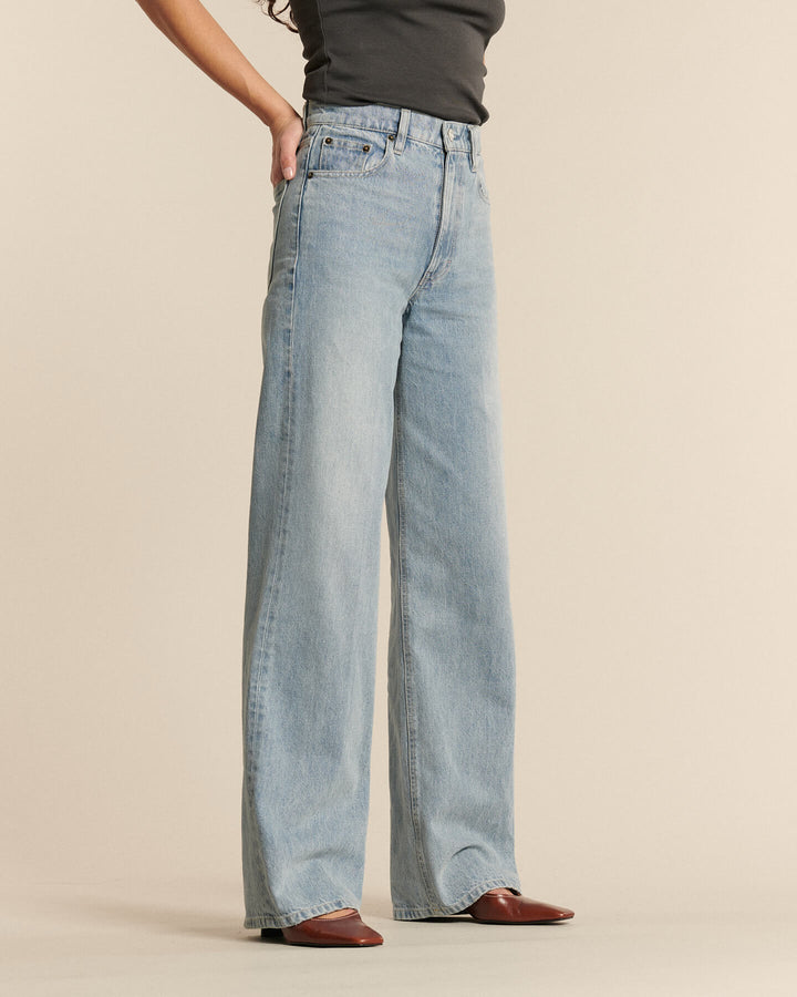 Jean droit femme en denim bleu clair avec effet stone wash, coupe ample et fluide, taille haute et matière 100 % coton pour un confort naturel.