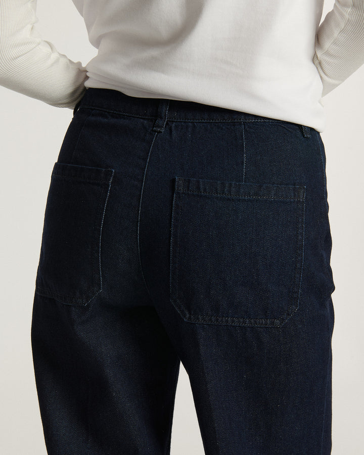 Jean femme en denim brut bleu foncé, coupe droite avec poches arrière carrées, tissu 100 % coton offrant un ajustement confortable et naturel.