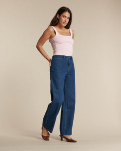 Jean en denim bleu moyen, coupe droite et taille haute, en coton dense offrant un tombé fluide et un ajustement confortable pour toutes morphologies.