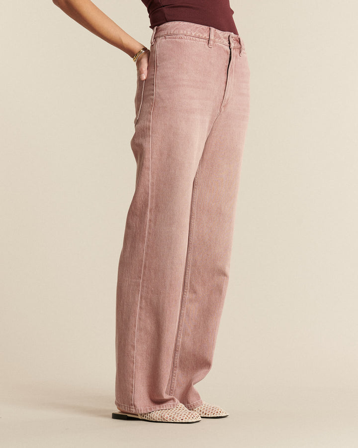 Jean large en denim rose poudré, coupe droite et fluide, matière 100 % coton offrant un tombé confortable et adapté à toutes les morphologies.