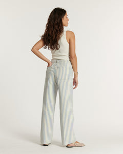 Jean pour femme en coton à rayures bleu clair et blanc, coupe droite et taille haute, offrant un style estival et décontracté adaptable à toutes les morphologies.