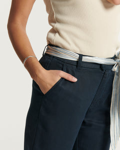 Jean marine en tissu Tencel fluide, coupe droite et ajustée, avec ceinture en tissu nouée à la taille pour un style féminin et confortable.