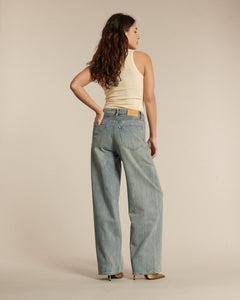 Jean en denim bleu clair avec une coupe droite et large, matière en coton souple, idéal pour une silhouette féminine adaptable à toutes les morphologies.