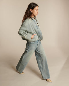Jean femme en denim bleu délavé, coupe droite et ample, en coton, offrant un confort et une silhouette adaptable à toutes les morphologies.