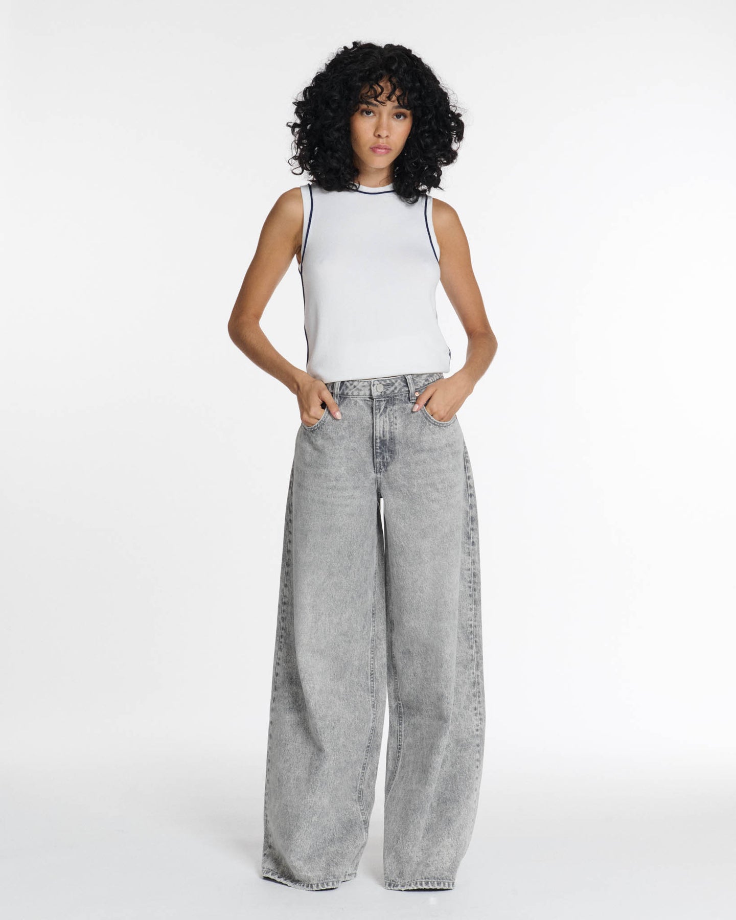 Jean femme en denim léger gris clair, coupe large et fluide, matière en coton confortable, conçu pour s’adapter à toutes les morphologies.
