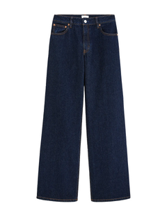 Jean femme en denim bleu foncé 100% coton avec coupe droite large, matière rigide et couture marron contrastante pour un style casual et adapté à toutes les morphologies.
